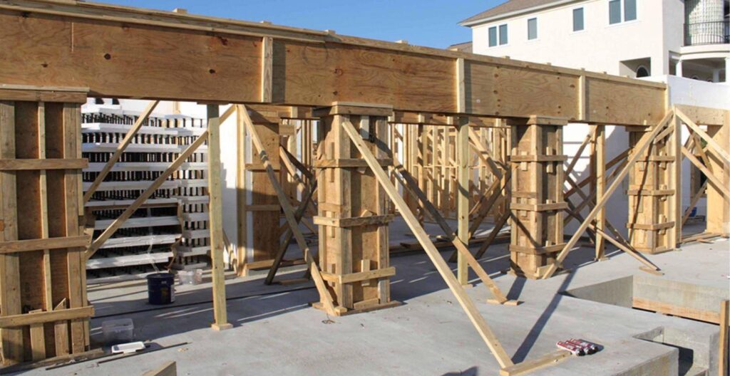 Estrutura de escoramento e formas de madeira sustentando concretagem em obra.