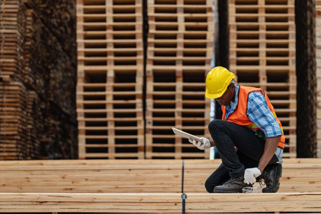 Engenheiro inspecionando madeira estrutural conforme normas técnicas da construção civil.